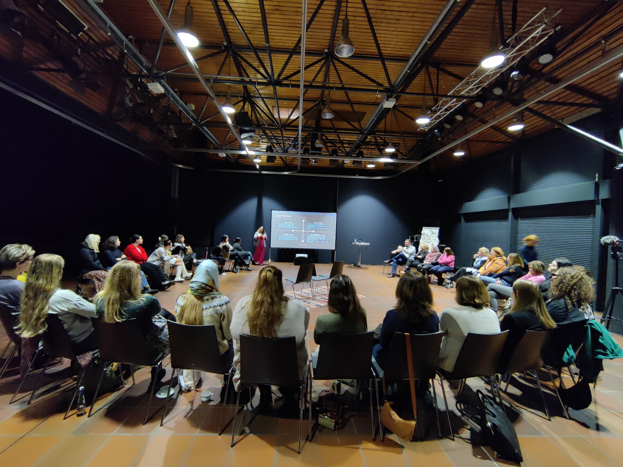 Selma presenting to women seated in a workshop circle