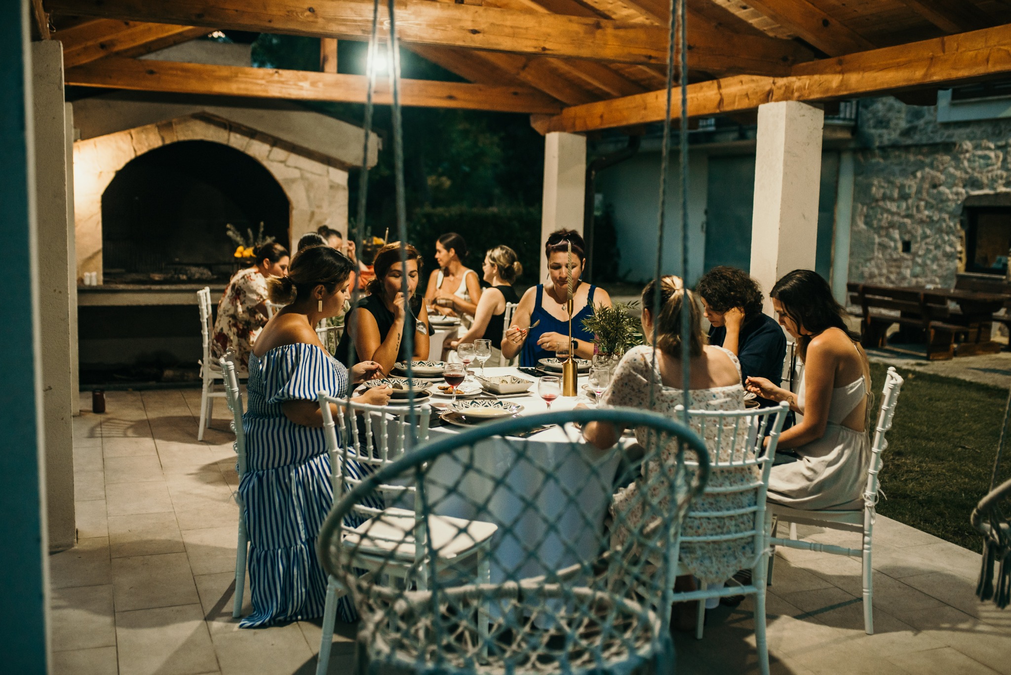 Women gathered around an outdoor table during an evening together
